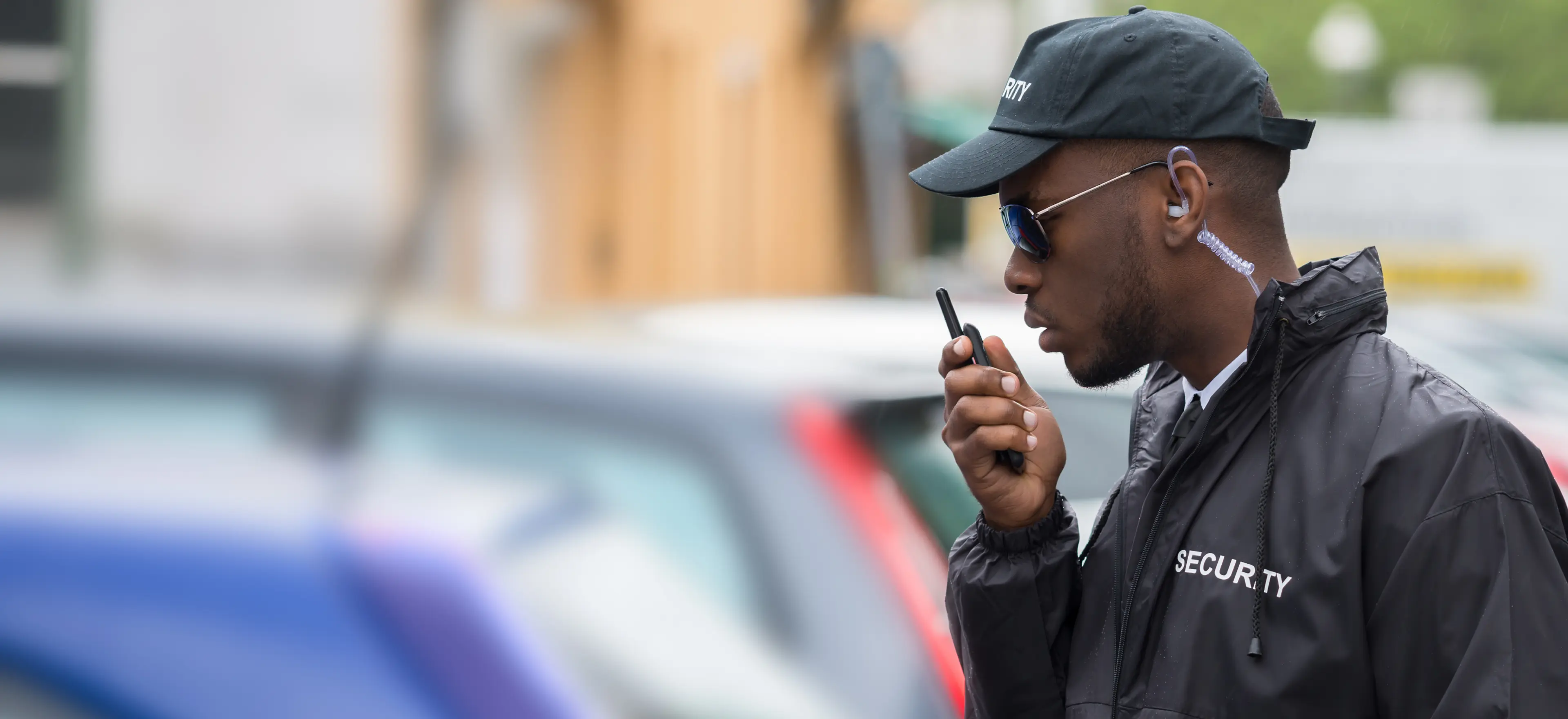 Security guard communicating via handheld radio.