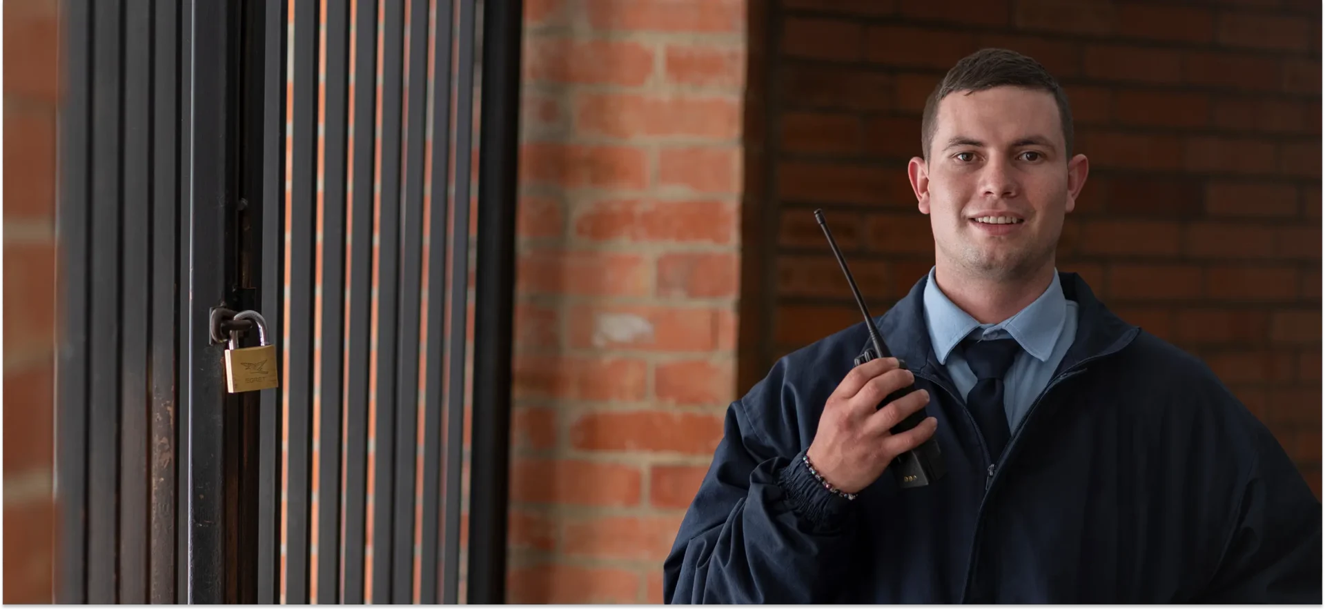 Security guard holding a walkie-talkie, smiling.