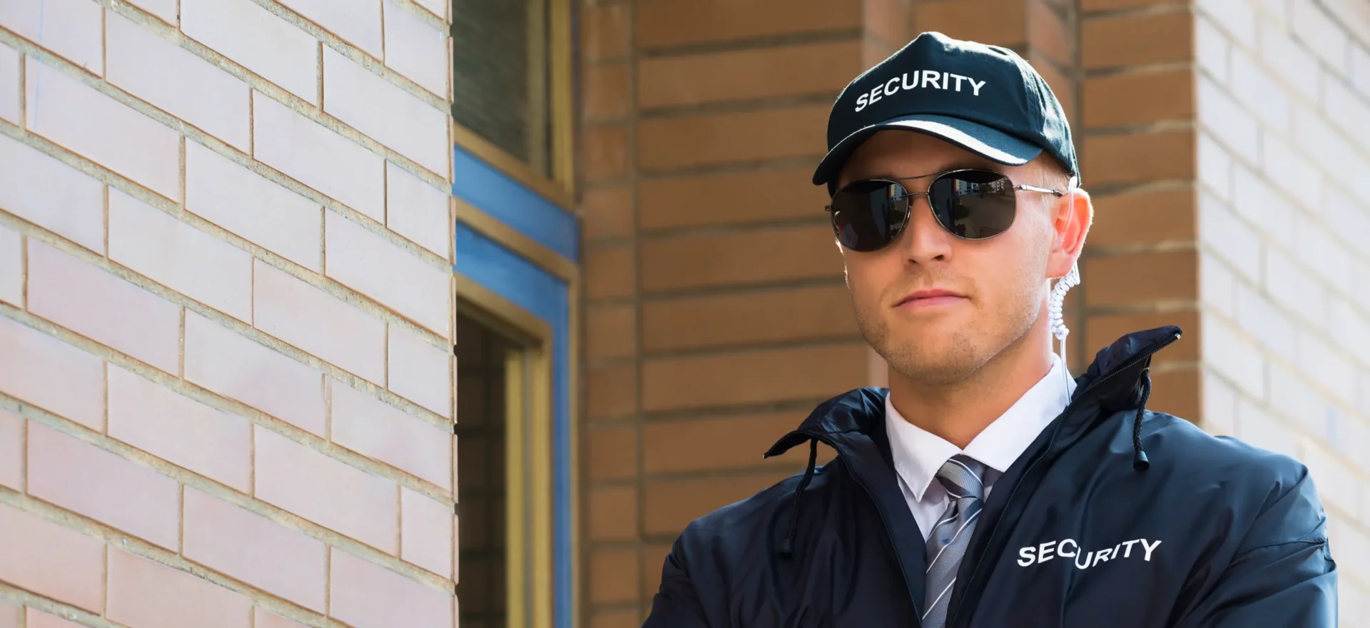 Security guard in uniform and sunglasses outside.